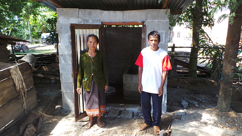 Frau Tau Lanh und der Dorfälteste stehen vor den neu errichteten Toilette.